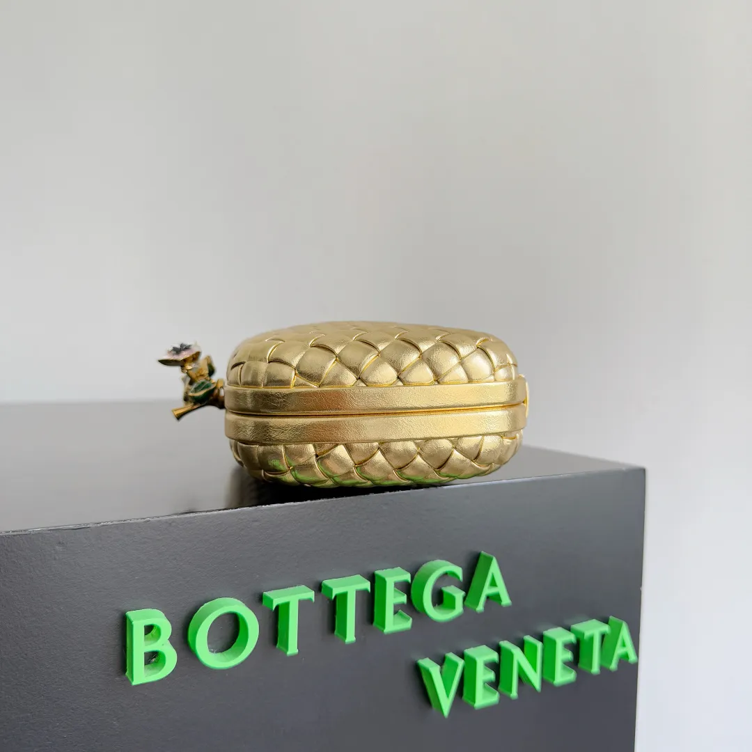 Batch 2100 BOTTEGA VENETA Women's Knot Evening Bag. An evening bag as beautiful as a jewelry box. Sharp-eyed friends must have discovered that the leather this time has a metallic luster. The whole bag looks very high-end. Even in a low-light environment, it is difficult to hide the excellent gloss of this bag. The three-dimensional flower made of brass will not oxidize. It is a heavy workmanship visible to the naked eye. Style number: 826183 (717622) Color: gold Size: 19*11.5*5cm